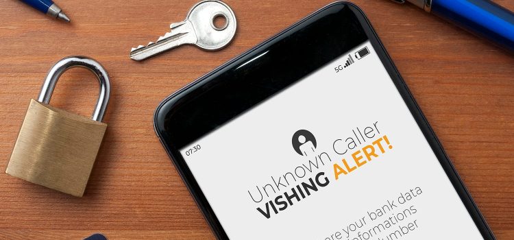 Vishing (voice phishing) concept, a smartphone on a table show an unknown caller call with vishing alert and a reminder to not share bank data, personal informations and credit card number